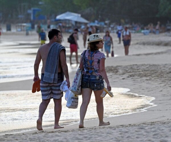 German tourists relaxing on Mirissa Beach during a tropical holiday in Sri Lanka